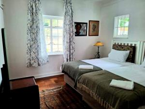 a bedroom with two beds and a window at Sensitively restored spacious apartment in Durban