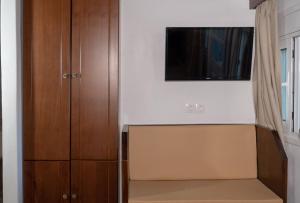 a living room with a tv and a cabinet at Liva Mare - Serifos in Livadakia