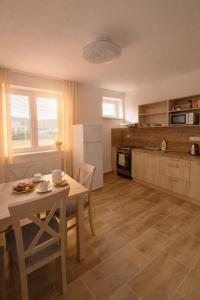 a kitchen with a table and a table and chairs at Pohoda Stay in Revúca +5 photos