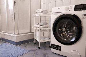 a washing machine sitting in a bathroom with towels at Traussegghof Ferienhaus Familie Uhl in Tanzelsdorf