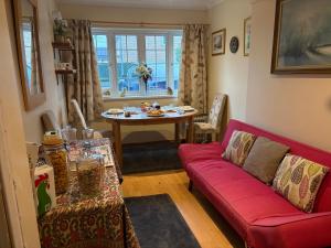 a living room with a red couch and a table at Were House Warminster in Warminster