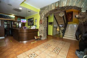 a lobby of a restaurant with a bear statue at Hotel Bitoraj Fužine in Fužine
