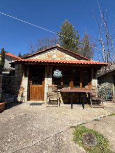 a house with two chairs and a table in front of it at Septem Mountain House in Eptalofos
