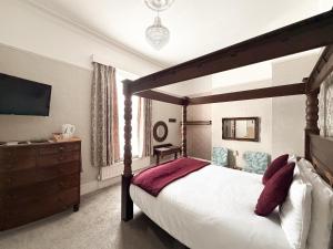 a bedroom with a canopy bed and a dresser at The Raincliffe Hotel in Scarborough