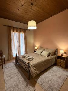 a bedroom with a large bed and a wooden ceiling at Septem Mountain House in Eptalofos