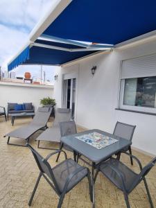a table and chairs on a patio with a blue awning at Romy Blu in Capri