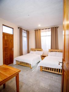 a room with two beds and a table at Kiliscape Hotel Moshi in Uru +13 photos