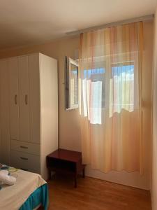 a bedroom with a bed and a window and a dresser at Apartmani VV in Cetinje
