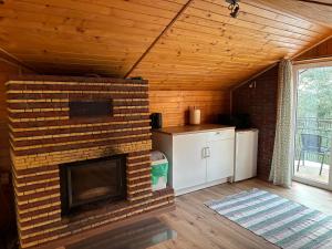 a living room with a brick fireplace in a house at Świerkowe Wzgórze in Grabków