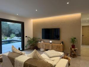 a living room with a couch and a tv on a wall at Casa di Macchjerolu - 8 pers in Sotta