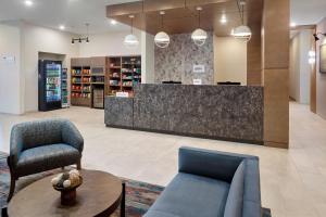 a lobby with chairs and a counter in a store at SpringHill Suites by Marriott Locust Grove in Locust Grove