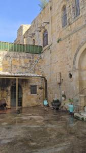 an old stone building with two blue chairs in front of it at Al qasr in Mashabbe Sade