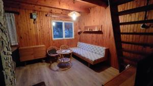a room with a couch and a table and a window at Chata Seč II in Bojanow