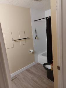a bathroom with a toilet and a bath tub at Charming 2-Bedroom House in Central Calgary in Calgary +51 photos