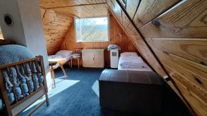 a room with a attic with a bed and a window at Chata Seč II in Bojanow +11 photos