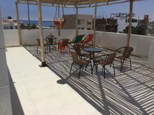a patio with chairs and tables on a roof at Paracas Backpackers House in Paracas