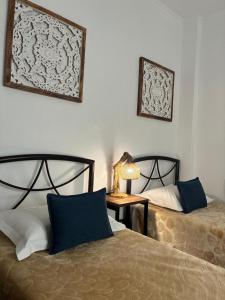a bedroom with two beds and a table with a lamp at Thanos ,Rooms and Apartments in Ouranoupoli