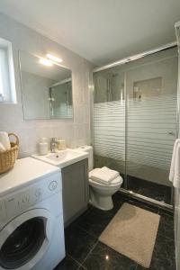 a bathroom with a washing machine and a toilet at Nafplio Cottage-Grandma's Yard in Asíni +22 photos