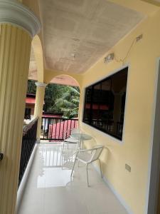 a room with a table and chairs on a balcony at Villa Nicolasa in Siquijor