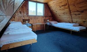 a room with two beds in a wooden cabin at Chata Seč II in Bojanow