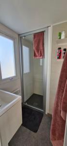 a bathroom with a shower with a glass door at Chalet B2 900 m vom Strand in Koudekerke