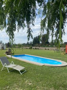a chair and a chair next to a swimming pool at Alojamiento en Paine cerca Monticello in Hijuela Larga
