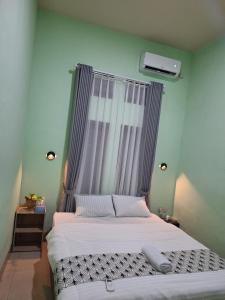 a bedroom with a large bed with a canopy at Jomariz Homestay in Labuan Bajo