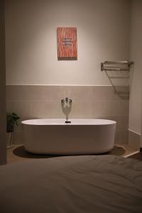 a bath tub in a room with a painting on the wall at 1909 Home Dalat - Open 24h in Ấp Kim Thạch +84 photos