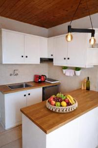 a kitchen with a bowl of fruit on a counter at Nafplio Cottage-Grandma's Yard in Asíni