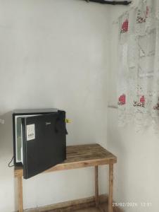 a television sitting on a wooden table in a room at Quitinete 5 Itaguaí in Itaguaí