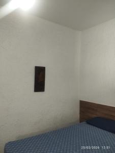 a bedroom with a bed and a picture on the wall at Quitinete 5 Itaguaí in Itaguaí
