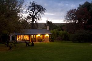 a small house in a field with the lights on at La Caledonia Cabañas Boutique in Sierra de la Ventana