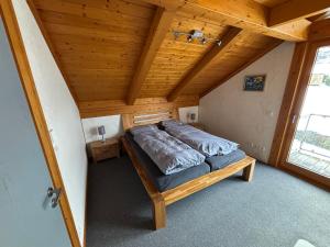 ein Bett in einem Zimmer mit Holzdecke in der Unterkunft Ferienwohnung Schillerstaße in Haiger