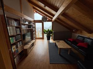 ein Wohnzimmer mit Sofa, Tisch und Büchern in der Unterkunft Ferienwohnung Schillerstaße in Haiger