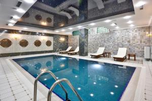 a pool in a hotel with chairs and a swimming pool at Alermo Hotel-SPA in Baku