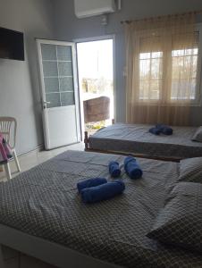 two beds with blue pillows on them in a bedroom at Vila marmelada in Leptokarya