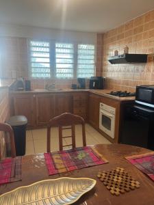 a kitchen with a table and a stove top oven at Kaz Toutoune in Saint-Leu