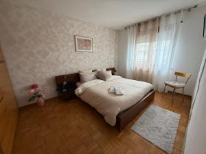 a bedroom with a bed and a chair in it at Casa vacanza AIRPORT CALVO in Ronchi dei Legionari