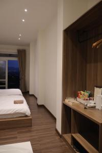 a hotel room with a bed and a desk at 1909 Home Dalat - Open 24h in Ấp Kim Thạch