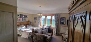 a bedroom with a bed and a chair and a window at Hay Farm House in Ford