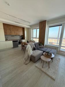 a large living room with a couch and a table at Bird's eye Apartment with sea view 18th floor in Klaipėda