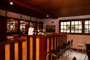 a bar in a restaurant with tables and chairs at Hotel Girassol in Penedo