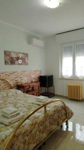a bedroom with a bed and a table and two windows at La Casetta Di Cotignola in Cotignola