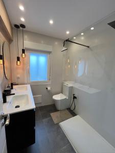 a bathroom with a sink and a tub and a toilet at Balcón del cubo in Covaleda