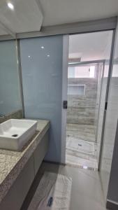 a bathroom with a white sink and a shower at Araras Apart Service in Caldas Novas