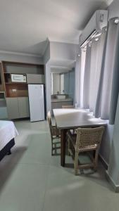 a kitchen with a table and chairs and a refrigerator at Araras Apart Service in Caldas Novas