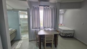 a small room with a table and chairs and a bed at Araras Apart Service in Caldas Novas