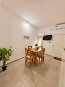 a dining room with a table and chairs and a tv at Pausa Bragado in Bragado