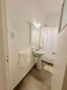 a white bathroom with a sink and a mirror at Pausa Bragado in Bragado +5 photos