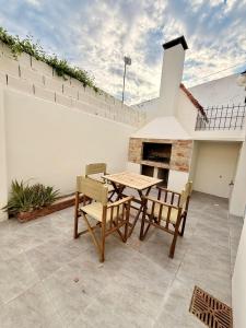 a patio with a table and chairs and a fireplace at Pausa Bragado in Bragado